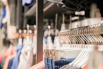 Clothes hangers on a rack with clothes and very shallow focus, for templates, storefronts, design...