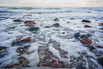 Baltic sea and sky. Big stone in the water - stormy weather. Long exposure.