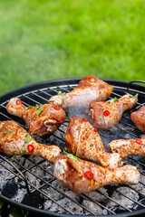 Chicken Drumsticks Legs Grilled on Charcoal BBQ in Backyard Garden at Summer Picnic