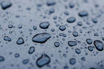 Blue background with water drops on a car.