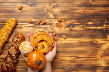 woman's hand holding bread on wooden floor