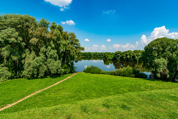 Fototapeta premium Beautiful natural scenery of river. Panoramic view of valley of river. Peaceful summer landscape with green hills, beautiful woods, meadows, river curves and fields