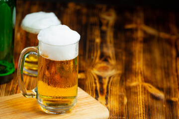A glass of beer is placed on the wooden floor.