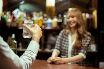 カウンターバーでお酒を提供する若い女性