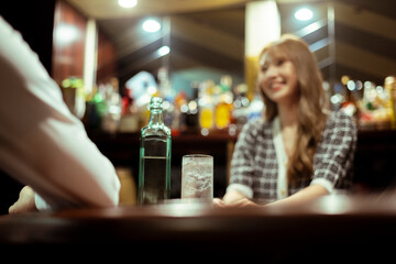カウンターバーでお酒を提供する若い女性