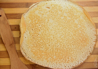 Stack of homemade pancakes on wood cooking board