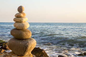 Balanced stones on the seashore summertime and sea background