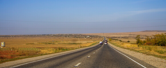 Road and moving cars at daytime and blue sky over