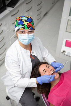 Dentist working on patient girl seen from above.