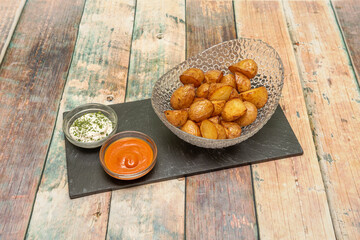 Updated version of fried patatas bravas with the skin and accompanied by spicy sauce and mayonnaise