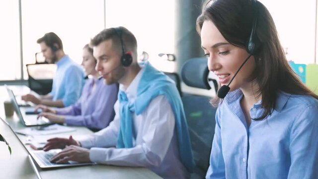 Attractive positive young businesspeople and colleagues in a call center office.