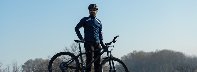 Conquering mountain peaks by cyclist in shorts and jersey on a modern carbon hardtail bike with an air suspension fork .