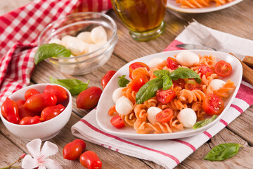 Fusilli pasta with cherry tomatoes and mozzarella cheese.