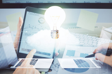 Double exposure of man's hands holding and using a digital device and bulb hologram drawing. Idea concept.