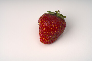 One berry of ripe strawberries on a white background.