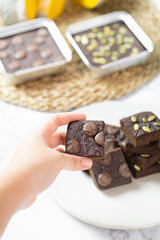 flourless pumpkin chocolate brownies set on white cafe table.