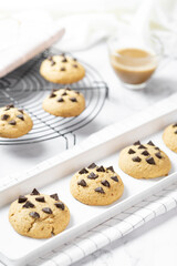 Delicious Whole Wheat Chocolate Chip Cookies set on white cafe table.