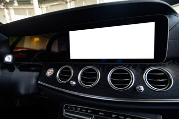 A close up on a car panel with white monitor for design, radio, player and control buttons.