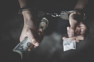 The drug dealer was arrested in handcuffs, drugs money  in concept about danger and threat of the...