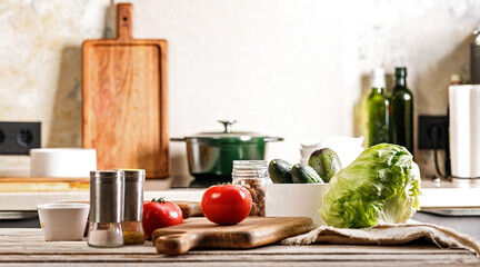 Delicious and healthy vegetables. Ripe tomatoes, fresh cucumbers and crispy ice salad, avocado. Food banner. Kitchen accessories. Chopping wooden boards and utensils. Modern kitchen still life