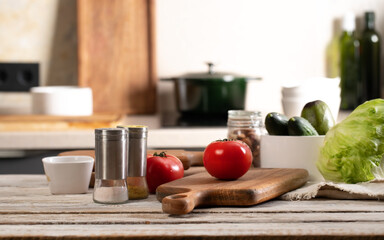 Delicious and healthy vegetables. Ripe tomatoes, fresh cucumbers and crispy ice salad, avocado. Food banner. Farmed organic products. Chopping wooden boards and utensils. Modern kitchen still life