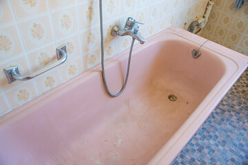 altes renovierungsbedürftiges Bad im Oma-Style, kaputte rosa Badewanne