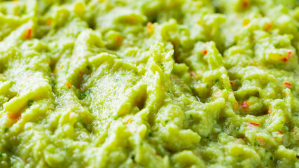 Guacamole close-up. Avocado guacamole sauce with fresh ingredients. Food background of guacamole...