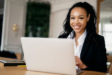 Female manager smiles working at home on a tablet. The accountant calculates the credit in the online table. Online distance learning via video link. Prints an email message to the client.