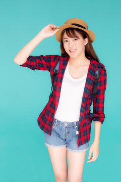 Beautiful portrait young asian woman holding hat smile expression cheerful and enjoy travel summer trip holiday in vacation isolated blue background, tourist happy asia girl confident and excited.