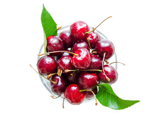 Ripe, red cherry in a glass bowl. Isolated cherries in the center of the photo on a light background. Natural vitamins in the summer.