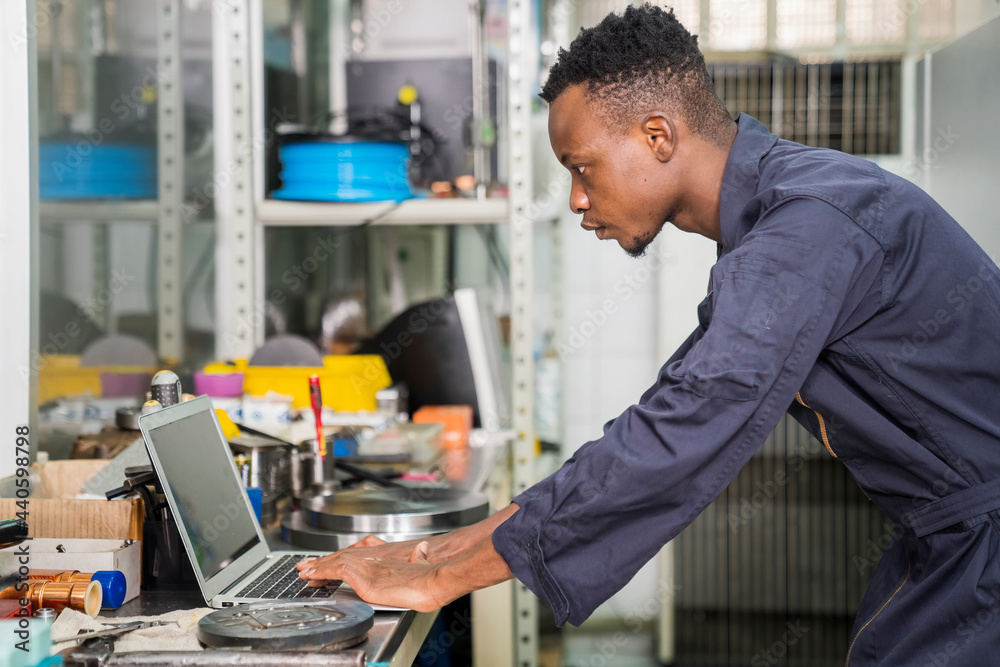 Wall mural Manufacturing worker. Professional African-American worker controlling the work. Cheerful Factory Worker Posing.