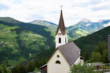 Fototapeta na wymiar Hoch über dem Gardertal - Dolomitenlandschaft mit der Kirche des Weilers Welschellen