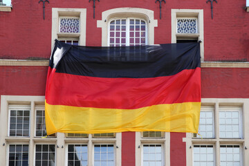 riesige deutschlandfahne an historischem gebäude