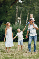 Fototapeta premium Family walks in a field and playing with toy plane