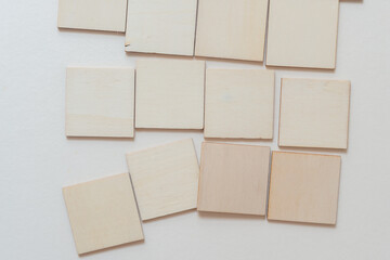 laser cut untreated or natural square wooden shapes arranged on a light background - photographed from above in a flat lay style with ambient light