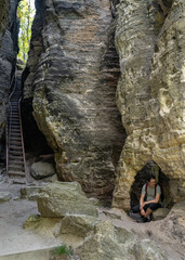 Adult male tourist enjoying surroundings at sandstone rock formations in Tisá, Czech republic. Film location of The Chronicles of Narnia