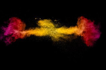 Abstract explosion of orange pink dust on black background.Freeze motion of orange pink powder burst.