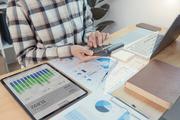 Fototapeta premium Business woman working in finance and accounting Analyze financial graph budget with calculator at home office.