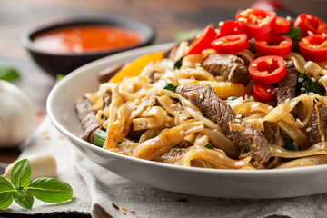 Stir fry Beef Chow Fun with rice noodles, bean sprouts, spring onions and chili.