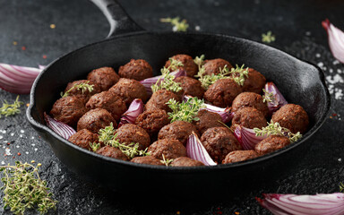 Vegetarian vegan meatballs with thyme and onion in cast iron skillet frying pan