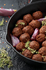 Vegetarian vegan meatballs with thyme and onion in cast iron skillet frying pan