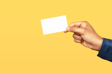 Businessman holding business card on yellow background. Business branding