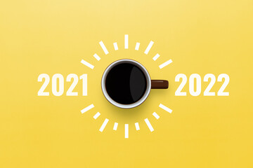 Happy new year 2022. Cup of coffee change 2021 to 2022 on yellow background. Start concept