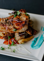 Restaurant meals beautifully prepared and arranged on plates with black background