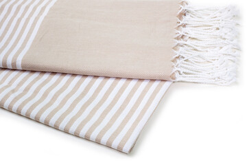 Beige and striped Peshtemal Turkish towel folded colorful textile for spa, beach, pool, light travel, healthy fashion and gifts. Traditional turkish bath material