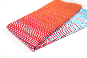 Colorful and striped, red Peshtemal Turkish towel folded colorful textile for spa, beach, pool, light travel, healthy fashion and gifts. Traditional turkish bath material - obrazy, fototapety, plakaty