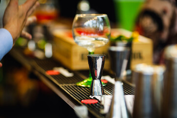 Shallow depth of field (selective focus) image with alcohol jiggers of a bartender on the counter of a bar.