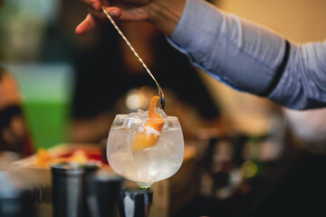Shallow depth of field (selective focus) image with a bartender preparing a cocktail.