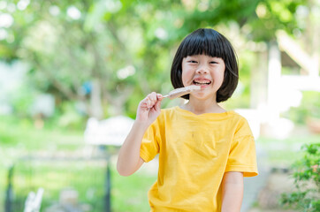 Fototapeta premium asian girl eating ice cream with blur background