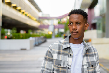 Portrait of African black man outdoors in city thinking during summer